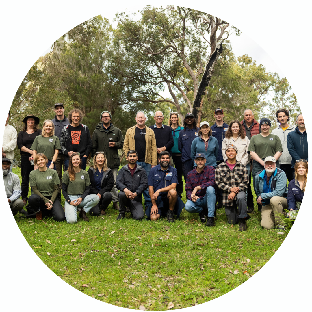 A large group of people posing for a photo in a park.